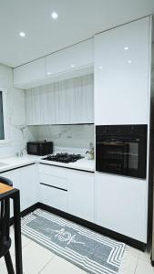 a kitchen with white cabinets and a stove top oven at Chez-moi in Sfax