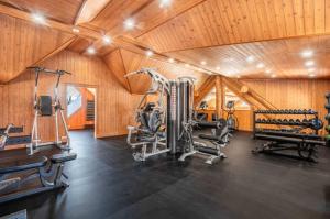 a gym with several tread machines in a wooden room at Spa Pool & Sauna - Laurentides Serenity in Mille-Isles