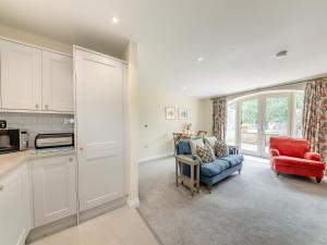 a kitchen and living room with a blue couch and a red chair at Nightfold - Uk49890 in Preston