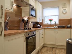 a kitchen with white cabinets and a sink at 15 Elm Court in Keswick