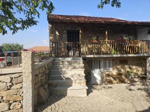 a stone building with a balcony and stairs at Cantinho de Tourêm in Tourém