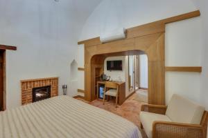 a bedroom with a bed and a desk and a fireplace at Silk Road Museum Hotel in Tokat