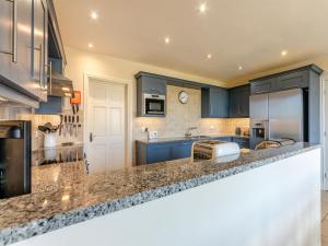 a kitchen with blue cabinets and granite counter tops at Carriage House - Uk49288 in Preston