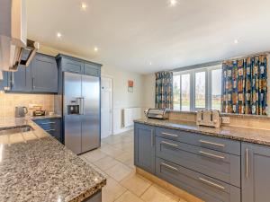 a kitchen with blue cabinets and stainless steel appliances at Carriage House - Uk49288 in Preston +24 photos