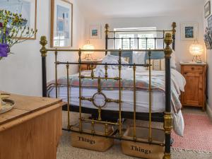 a bedroom with a bed with a metal frame at Tan Bryn - Uk44151 in Llanallgo