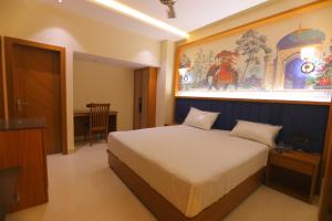 a bedroom with a bed with a painting on the wall at Chunmun Elite Retreat in Bulandshahr +12 photos