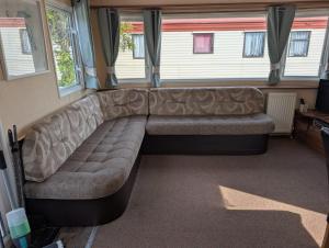 a couch sitting in the middle of a room at Robin hood rhyl Ll18 3uu in Rhyl