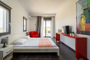 a bedroom with a bed and a red chair at Sani Invictus Villa in Sani Beach +31 photos