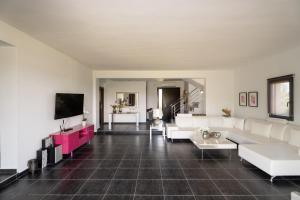 a living room with white furniture and a flat screen tv at Sani Invictus Villa in Sani Beach