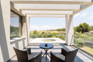 a balcony with a table and chairs and a view at Sani Invictus Villa in Sani Beach