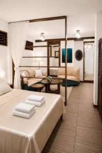 a bedroom with two beds and a living room at Feliz Puerta - Entire House with Rooftop Terrace, Iquitos in Iquitos