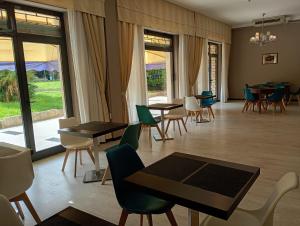 a dining room with tables and chairs and windows at Hotel Europa in Arma di Taggia