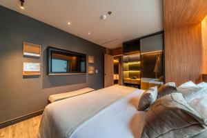 a bedroom with a large bed and a television at Laghetto Stilo São Paulo in São Paulo