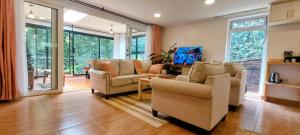 a living room with two couches and a table at Barnhouse Cottage - Sauna & Steam bath - in Tigoni in Nairobi