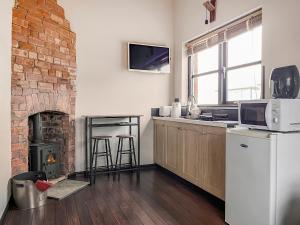 a kitchen with a brick fireplace and a counter with a microwave at The Weighbridge in North Clifton