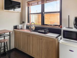 a kitchen with a counter with a microwave and a sink at The Weighbridge in North Clifton