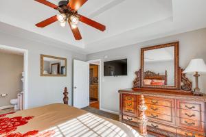a bedroom with a ceiling fan and a dresser with a mirror at Birmingham Haven New Deck King Bed No Cleaning Fee in Birmingham