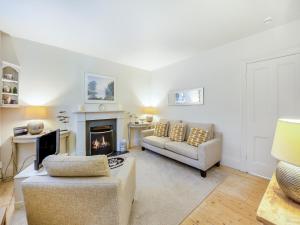 a living room with a couch and a fireplace at Chareside Cottage in Corbridge