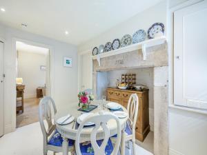 a dining room with a table and chairs and a fireplace at Chareside Cottage in Corbridge
