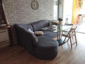 a living room with a leather couch and a table at The Urban Point Dobrich in Dobrich