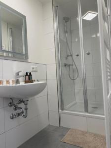 a white bathroom with a sink and a shower at Blue Stay 2 in Bremen