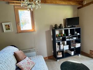 a living room with a tv and a couch at La Petite Maison De Rose in Flancourt-Crescy-en-Roumois