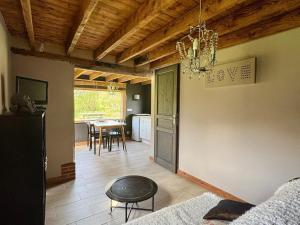 a living room with a table and a chandelier at La Petite Maison De Rose in Flancourt-Crescy-en-Roumois