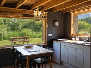 a kitchen with a table and a table and a window at La Petite Maison De Rose in Flancourt-Crescy-en-Roumois