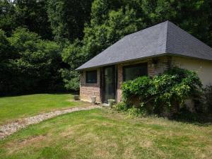 a small brick house in a grassy yard at La Chaumière in Flancourt-Catelon