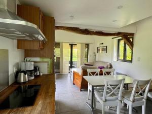 a kitchen and living room with a table and chairs at La Chaumière in Flancourt-Catelon
