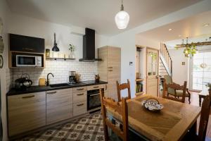 a kitchen with a wooden table and a dining room at Gîte les clés de l'émeraude in Bergnicourt