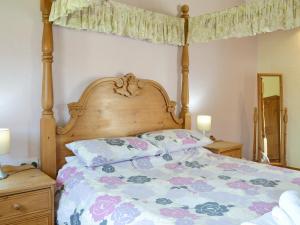 a bedroom with a bed with a wooden headboard and pillows at Meadow View - Iom in Brandesburton