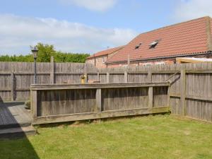 a wooden fence in a yard next to a house at Meadow View - Iom in Brandesburton