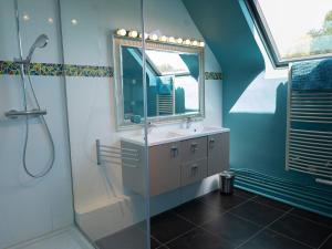 a bathroom with a sink and a shower with a mirror at La longère in Flancourt-Catelon