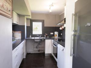 a kitchen with black and white counters and a sink at La longère in Flancourt-Catelon +21 photos