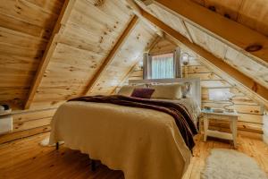 a bedroom with a bed in a wooden house at Peaceful Luxury in the Smokey Mountains w Hot Tub and Pet Friendly Cabin B in Elizabethton