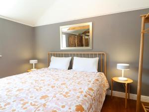 a bedroom with a bed and two lamps and a mirror at The Old Dairy in Warminster