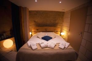 a bedroom with a bed with two towels on it at L'Escapade in Baugé