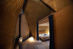a bedroom with a bed in a stone building at L'Escapade in Baugé