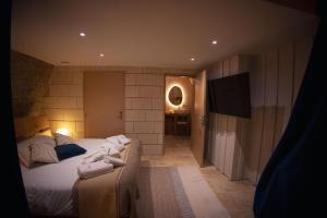 a bedroom with a bed with towels on it at L'Escapade in Baugé