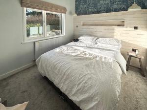 a bedroom with a large white bed with a window at St Mabyn Lodge Escape in Bodmin