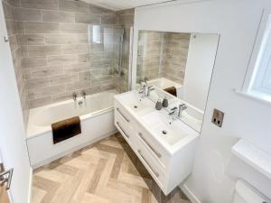 a white bathroom with a tub and a sink at St Mabyn Lodge Escape in Bodmin