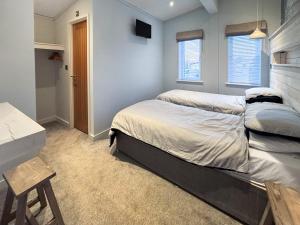 a bedroom with two beds and a desk in it at St Mabyn Lodge Escape in Bodmin