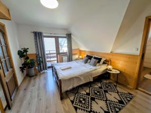 a bedroom with a bed and a large window at Willa Murań in Murzasichle