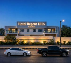two cars parked in a parking lot in front of a hotel resort dmg at Hotel Regent DHA in Karachi