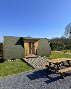 a cabin with a green roof and a picnic table at UCamp Kemmelberg in Heuvelland