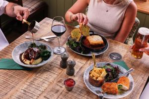 two people sitting at a table with food and wine at The Seaburn Inn - The Inn Collection Group in Sunderland
