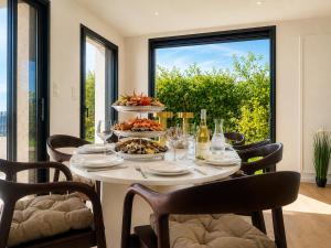 a table with food on it with chairs and a window at L Œil de L Horizon in Lanildut