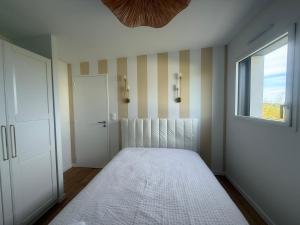 a bedroom with a bed and a window at L Œil de L Horizon in Lanildut