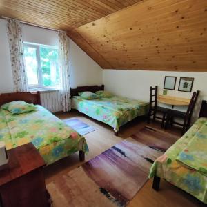 ein Zimmer mit zwei Betten und einem Tisch darin in der Unterkunft Cabana CODRIN in Rausor